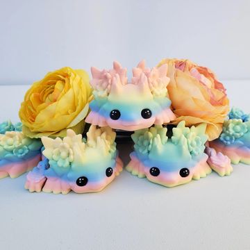 Colorful pastel axolotl figurines with large eyes and flowers.