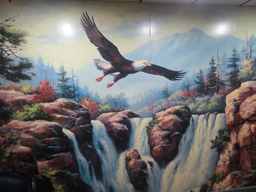 Painting of an eagle soaring over waterfalls and rocky cliffs.