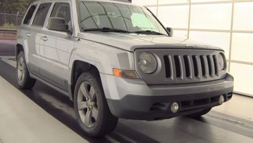 Silver Jeep SUV parked indoors.
