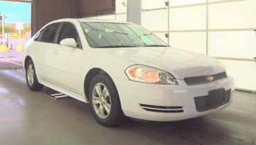 White Chevrolet sedan parked indoors.