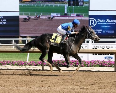Jockey riding a racehorse during a horse race on a dirt track.