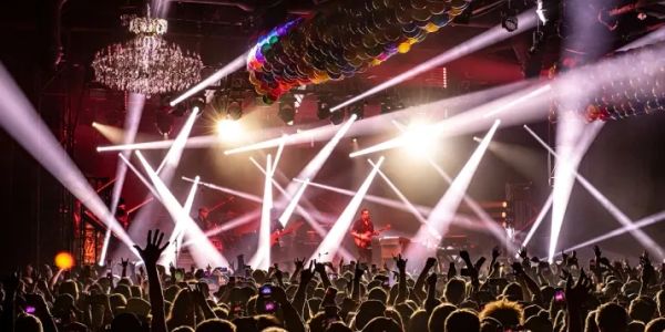 Concert crowd enjoying music with bright stage lights.