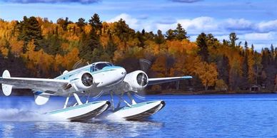A seaplane taking off from a lake with autumn trees in the background.