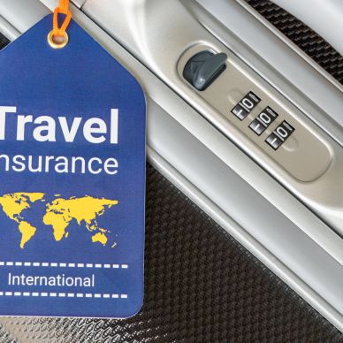 Travel insurance tag on a suitcase lock.