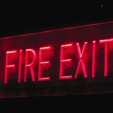 Red neon "FIRE EXIT" sign glowing.