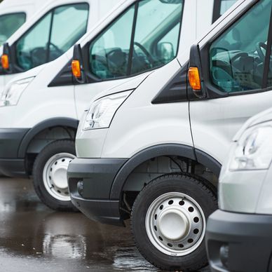 Line of white delivery vans parked.