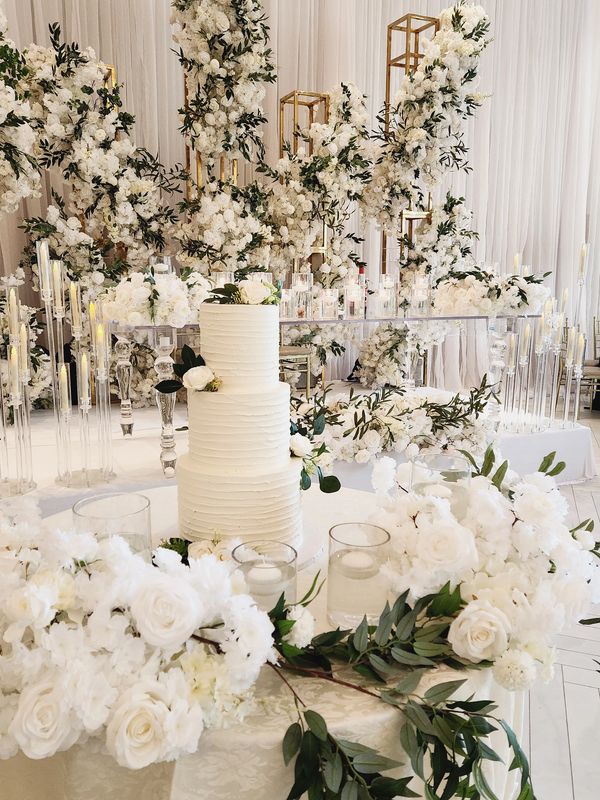 Elegant white wedding cake with floral decorations.