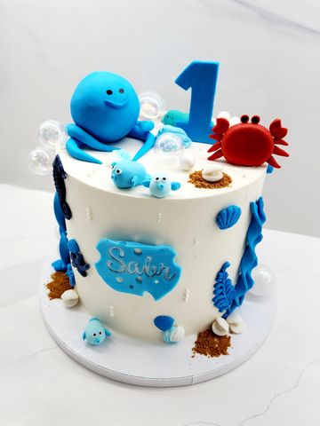 Undersea themed first birthday cake with ocean creatures.