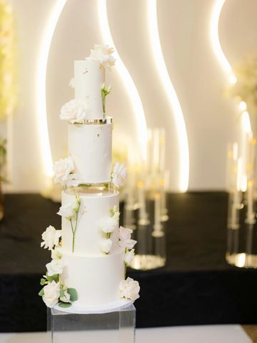 Elegant white tiered wedding cake with flowers.
