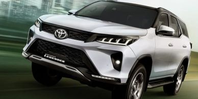 Silver Toyota Fortuner SUV driving fast.