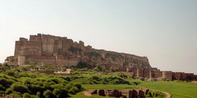 Large ancient fort atop a hill with green surroundings.