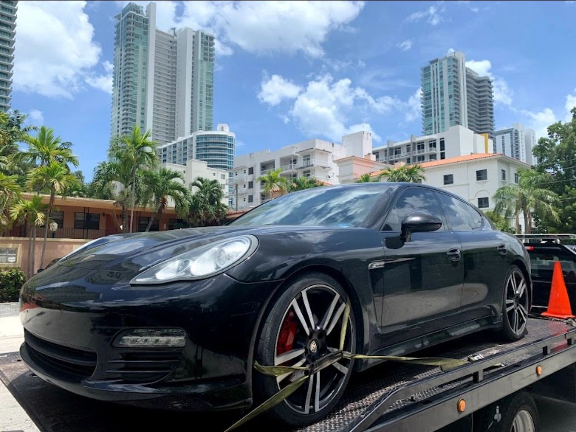 Porsche car with no key being towed on a flatbed near Miami Beach. Call today for a free quote.