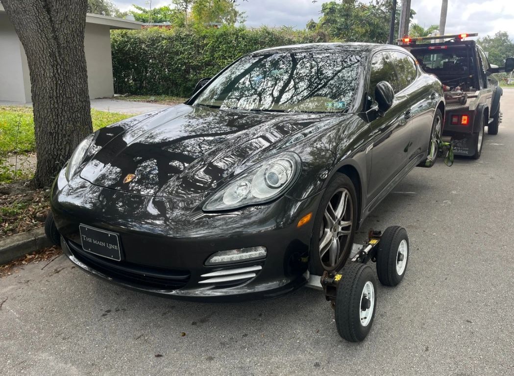Exotic car being towed by a tow truck in Miami Florida. Special equipment used are dollies.