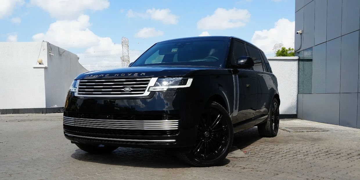 Sleek black Range Rover parked under a bright blue sky.