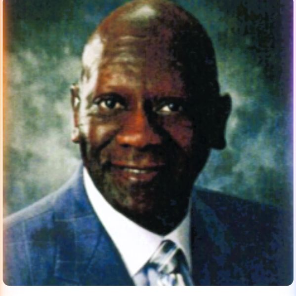 Portrait of a smiling elderly man in a suit and tie.