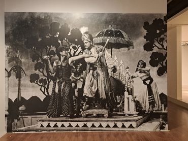 Black and white mural of a historical scene with people in traditional attire.