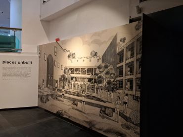 Detailed architectural mural depicting an urban street scene inside a gallery.