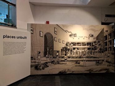 An exhibition wall titled 'places unbuilt' with architectural sketches and descriptions.
