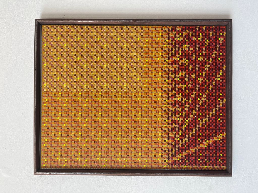 Framed pixel art with warm yellow and red tones forming a gradient pattern.