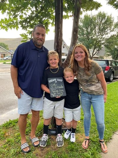 Happy family posing outdoors on the first day of school.