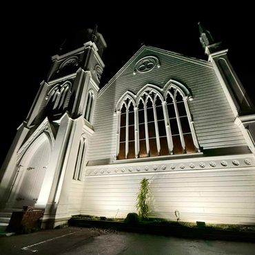 Beautiful simple white uprights at private function lighting up large church in Ponsonby.