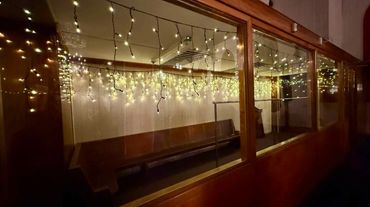 Warm white commercial-grade icicle lights indoors to light up cloak room at private function.