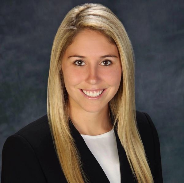 Professional portrait of a smiling woman with blonde hair.