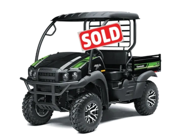 Black and green Kawasaki off-road utility vehicle with rugged tires.