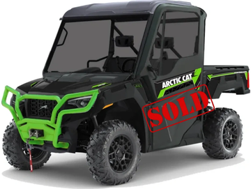 A black and green Arctic Cat utility terrain vehicle (UTV) with a closed cabin.