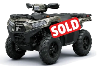 Camouflage-patterned Kawasaki all-terrain vehicle with rugged tires.