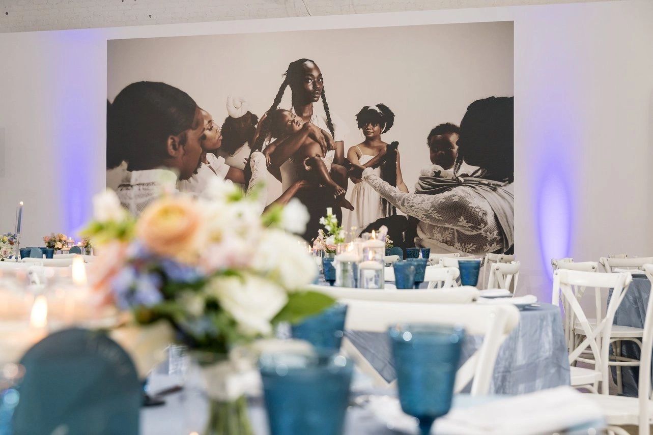 Wedding reception with a large family photo backdrop and elegant table settings.