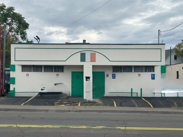 White building with green accents and Irish flag on top.