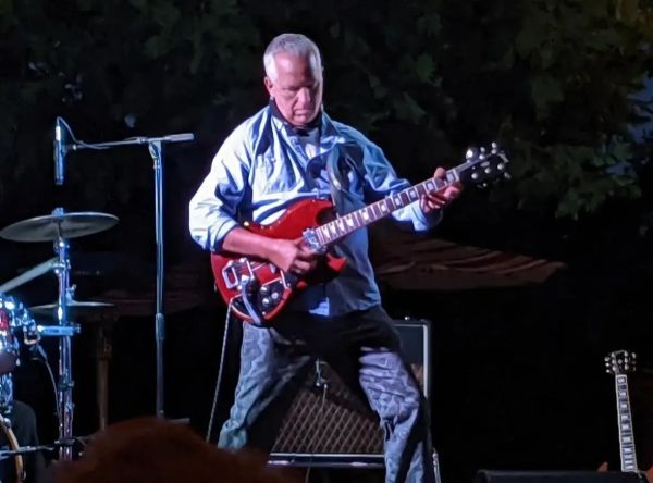 A serene landscape featuring rolling hills, a clear blue sky, and a tranquil lake reflecting the scenery.