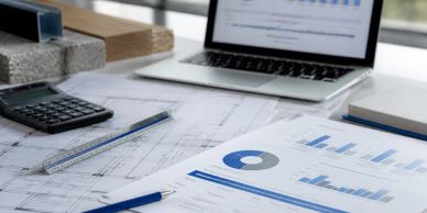 Workspace with financial charts and laptop.
