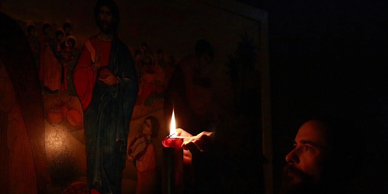 Brother Thomas lighting candle in Holy Wisdom Temple