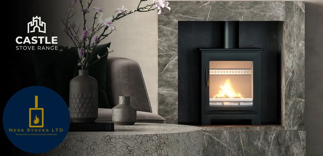 Modern black stove burning inside a stone fireplace with decorative vases nearby.