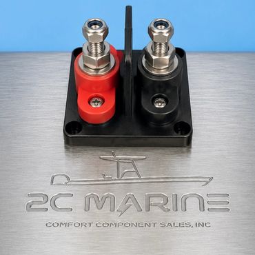 Close-up of a marine electrical terminal block with red and black connectors.