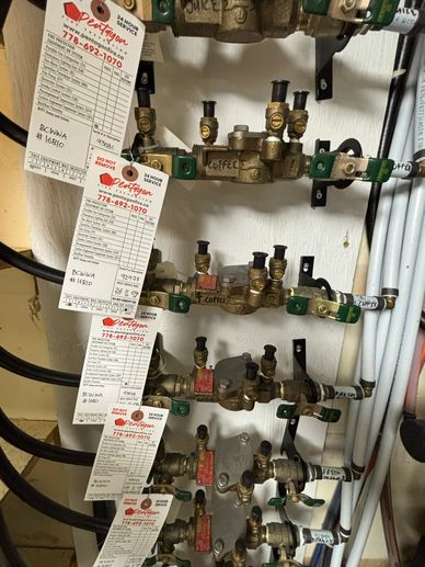 Labeled water valves with inspection tags attached.