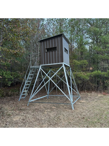 Elevated hunting blind with metal frame in a wooded area.