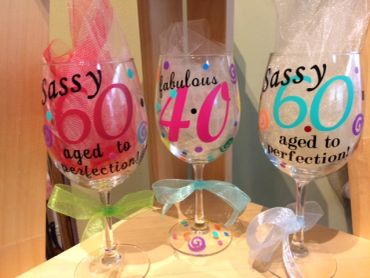 Three decorated wine glasses for milestone birthdays.