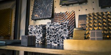 Metallic textured samples displayed on a shelf with varied patterns and finishes.