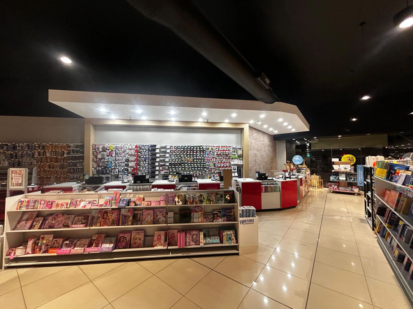 Interior of a well-lit stationery and book store with organized shelves and counters.