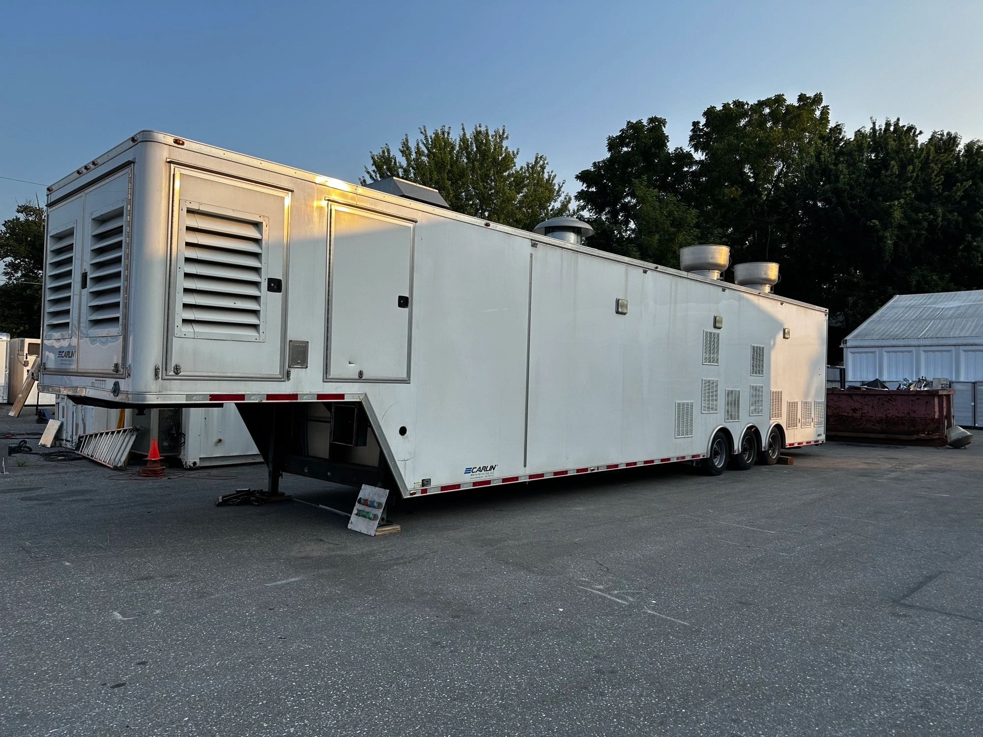 Large white industrial trailer with ventilation vents parked outdoors.