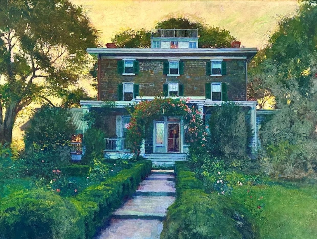 A large, classic house surrounded by lush greenery.