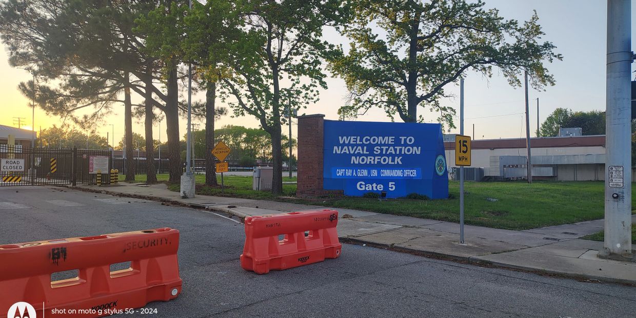 Naval Station Norfolk Gate 5 entrance sign on Hampton Boulevard with security checkpoint barriers — 