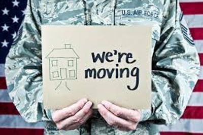 Soldier in military fatigues holding a sign saying " we are moving"