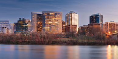 City skyline at dusk by a river with modern buildings.