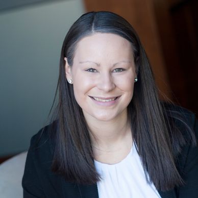 Smiling woman with straight dark hair in professional attire.