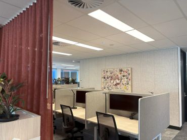 Modern office workspace with cubicles and chairs.
