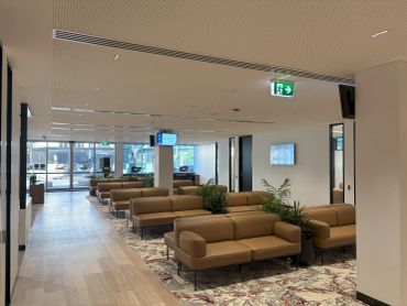 Modern waiting area with tan sofas and large windows.